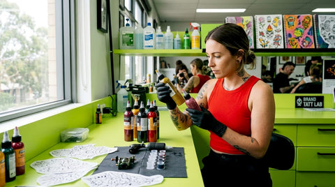 Tattoo artist examining professional ink bottles