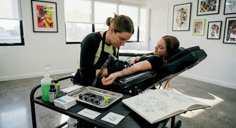Tattoo artist working on fine line arm tattoo